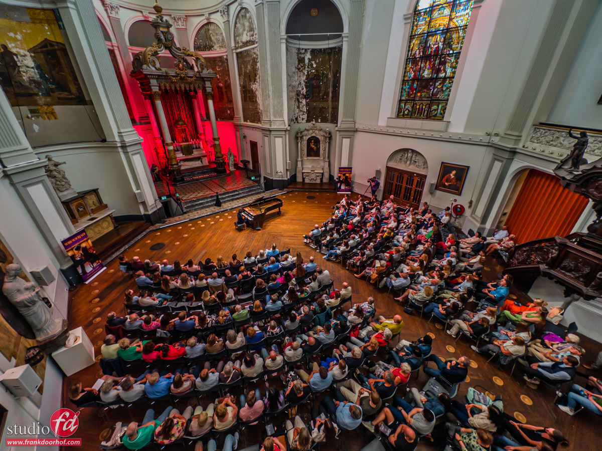 concert photography tips and tricks. shoot a concert from above, you see the audience, the former church and wibi playing the piano 